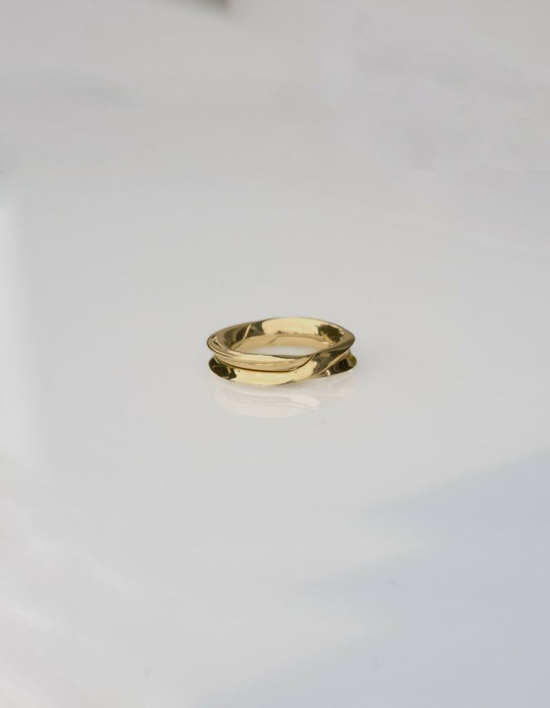 Two-piece gold ring with a polished surface, lying flat when closed