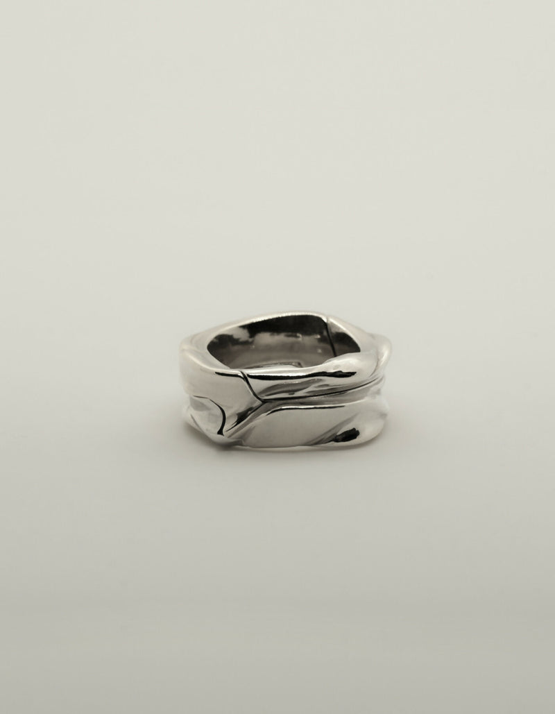 Two-piece silver ring with a polished surface, lying flat when closed.