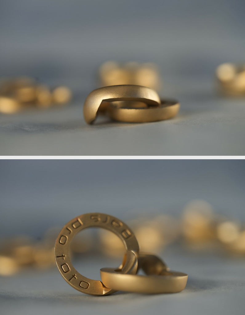 Two-part ring made of gold with a matt surface, slightly opened and open view, one half lying down, the other half standing upright. The hidden inner surfaces provide space for individual engraving.