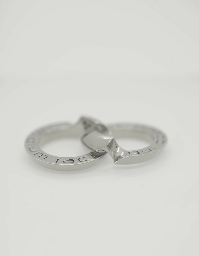 Two-piece silver ring with polished surface unfolded. An engraving can be seen on the hidden inside pages.