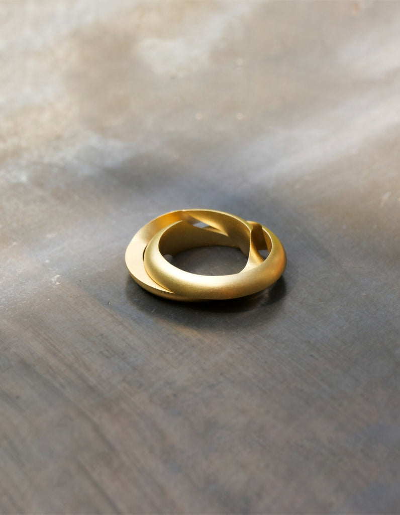 Two-piece ring made of gold with a matt surface, lying slightly open