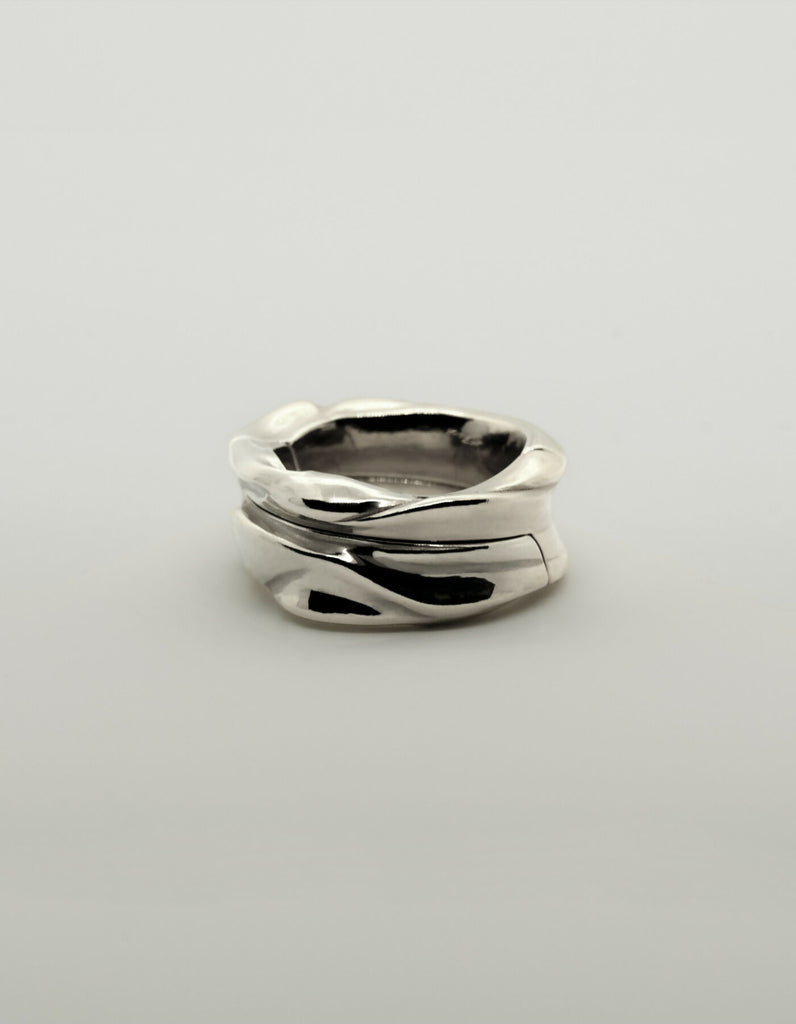 Two-piece silver ring with a polished surface, lying flat when closed.