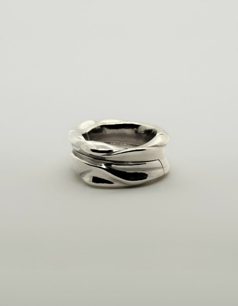 Two-piece silver ring with a polished surface, lying flat when closed.